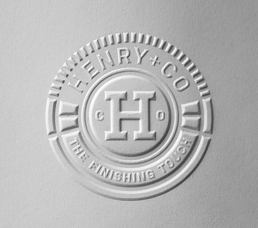 the logo for henry & co is shown on a white surface with silver lettering and a circular