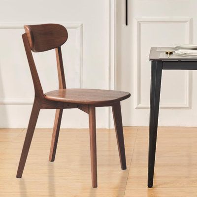 a wooden chair sitting next to a small table on top of a hard wood floor