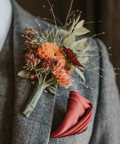 a boutonniere with an orange flower on the lapel of a man's suit