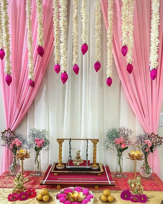 a decorated stage with pink drapes and white flowers