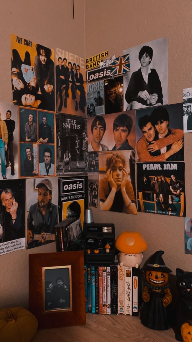 a room with many pictures on the wall and various items in front of it, including an orange chair