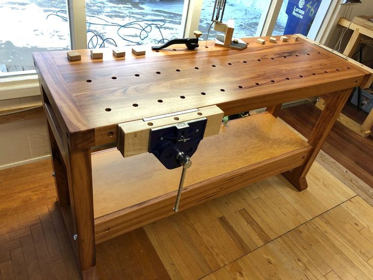 a workbench made out of wood with holes in the center and pegs on it