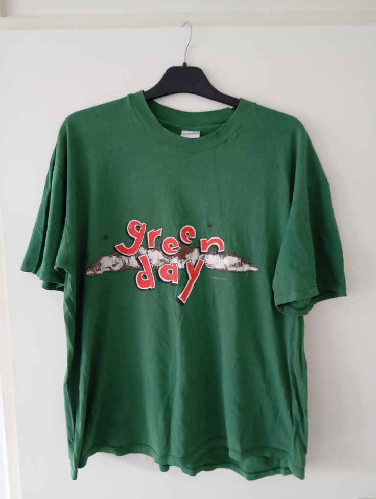 a green t - shirt with the words screen day on it hanging from a hanger