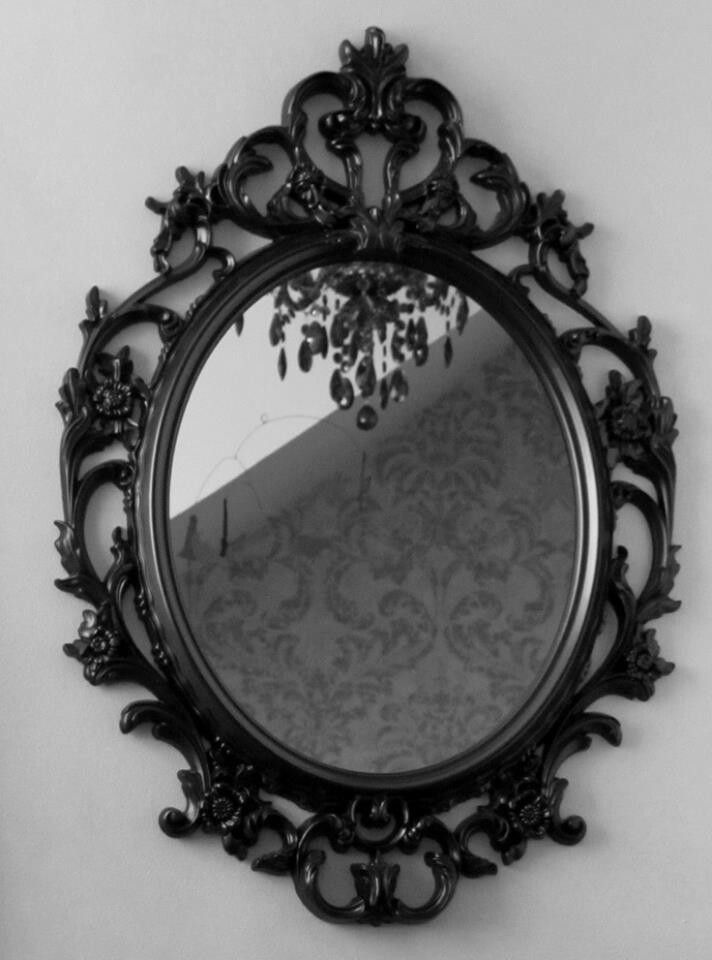 an ornately decorated mirror hangs on the wall