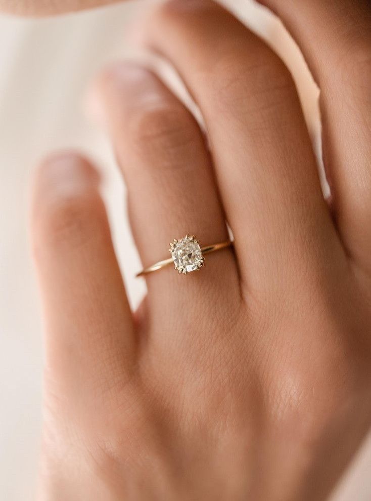 a woman's hand with a diamond ring on it