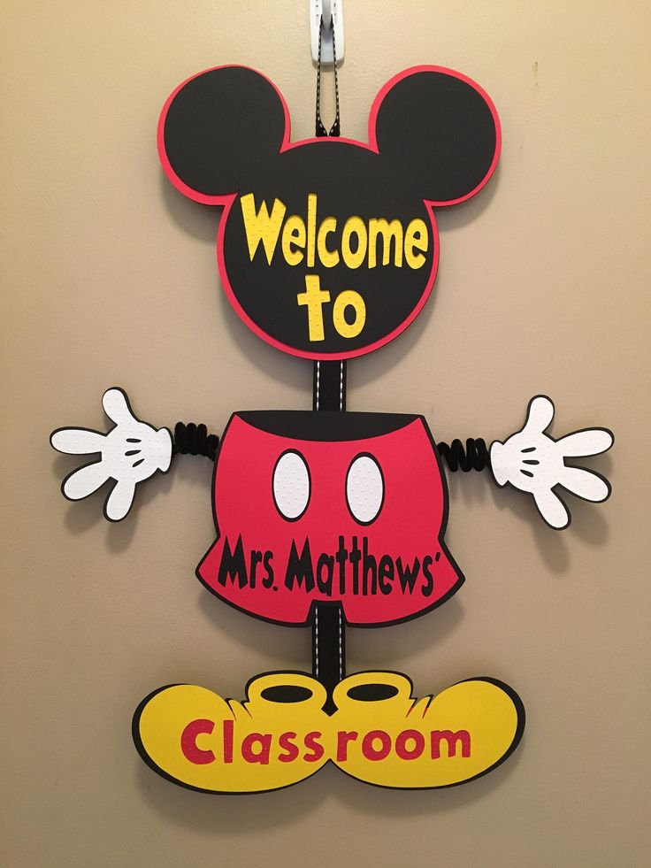 a mickey mouse welcome sign hangs on the wall next to a class room door hanger