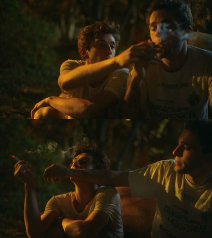 four people sitting around in the woods at night, one is holding something up to his mouth