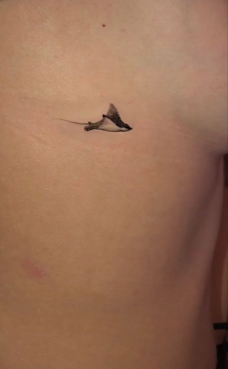 a small tattoo on the back of a woman's stomach