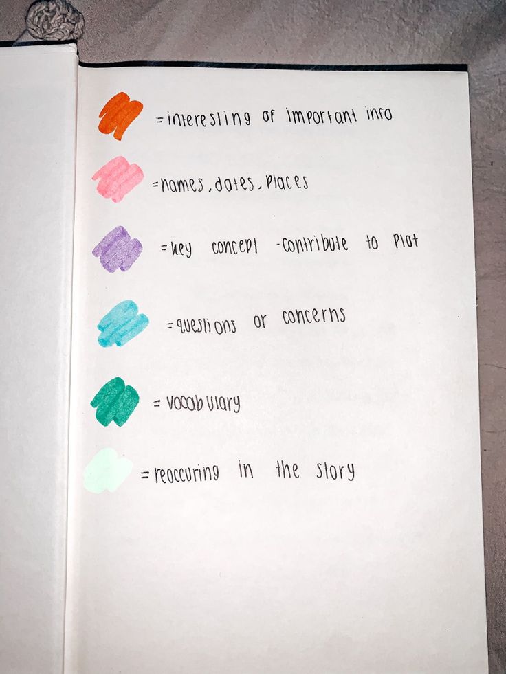 an open book with colored crayons on the pages and words written in different languages