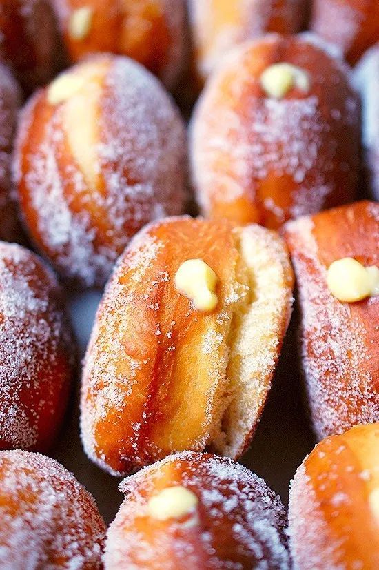 powdered sugar covered donuts with nuts on top