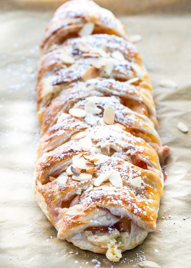 a pastry with almonds and powdered sugar on it