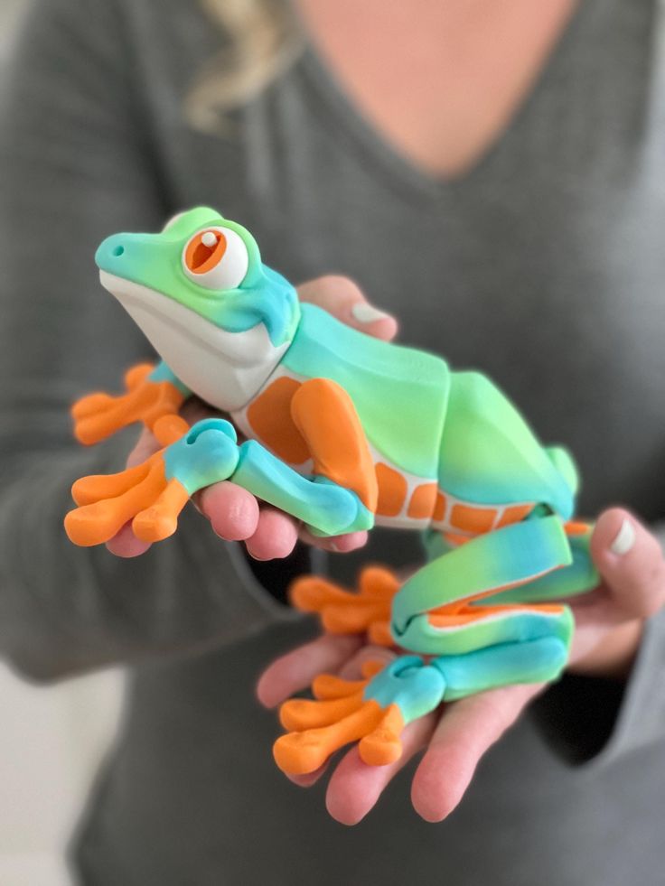 a close up of a person holding a toy frog