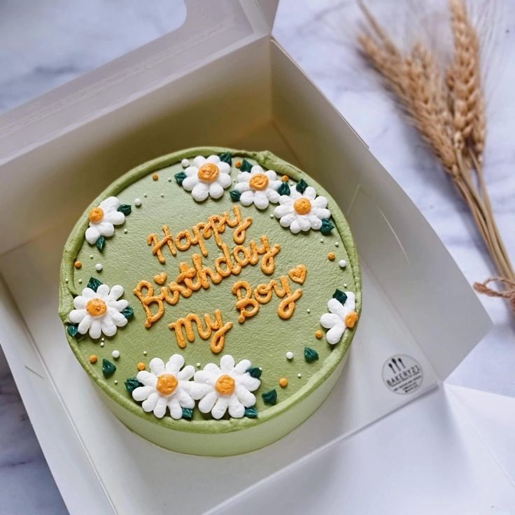 a green birthday cake with daisies and the words happy birthday my