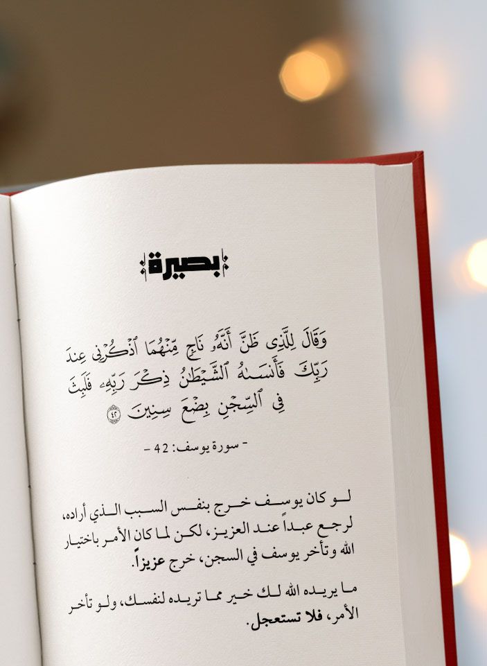 an open book with arabic writing on the page and lights in the backround