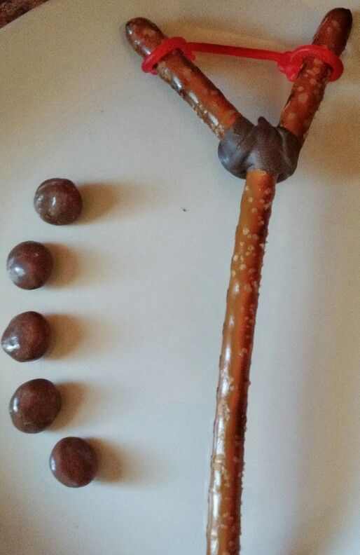 a white plate topped with chocolate covered pretzels and an orange string attached to it