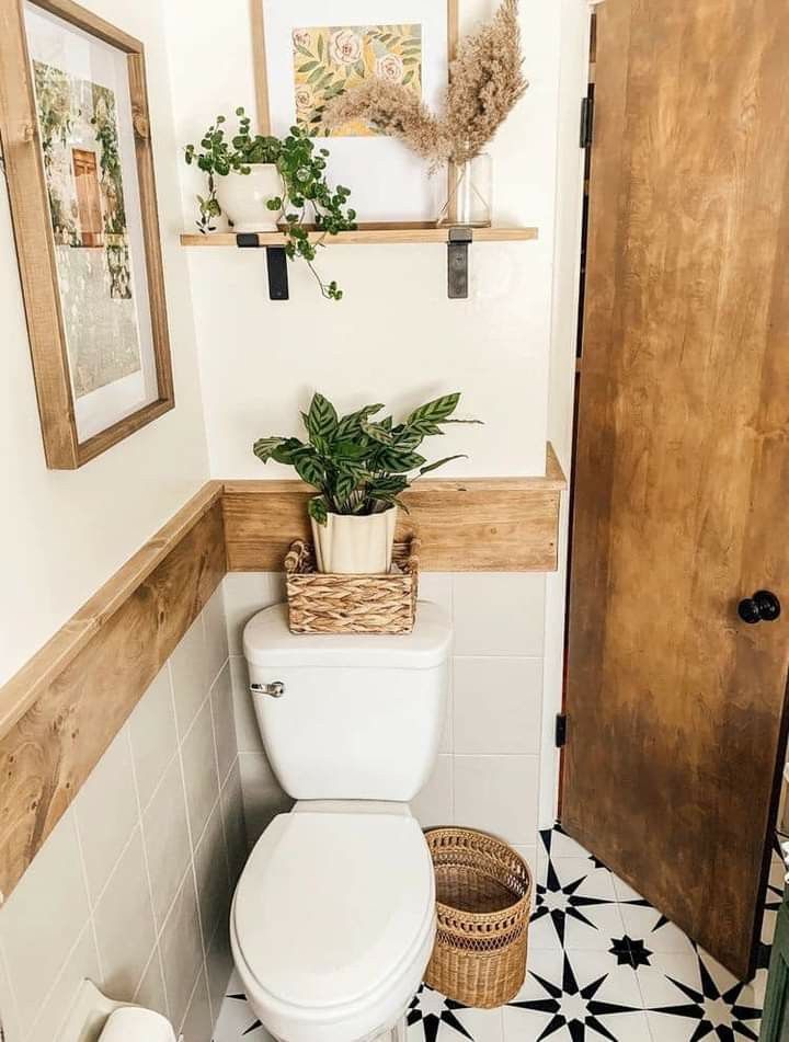 a white toilet sitting in a bathroom next to a wooden door and potted plant