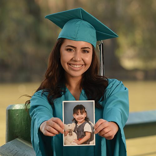 a woman in a cap and gown holding a photo