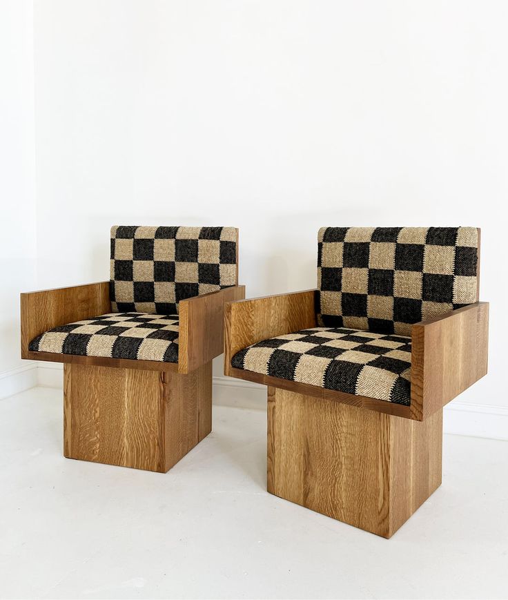 two wooden chairs with black and white checkerboard upholstered backrests