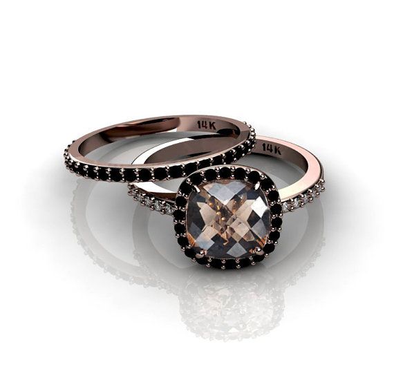 two wedding rings with black diamonds on each one and an oval shaped stone in the middle