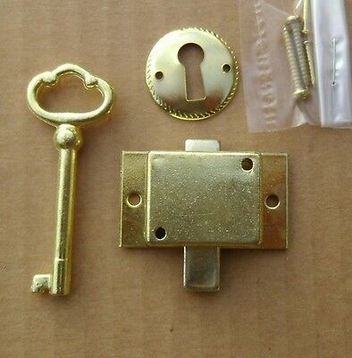 an open door with a key and some screws next to it on a table