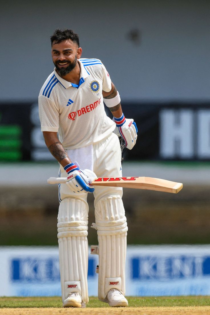 a man holding a cricket bat on top of a field