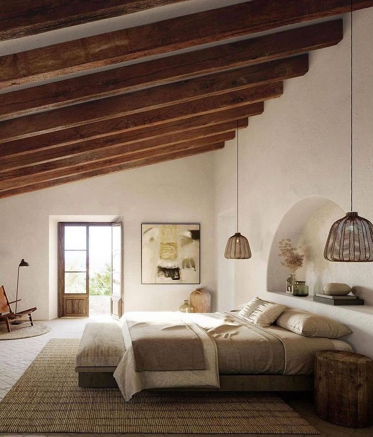 a bedroom with white walls and wooden beams, an area rug on the floor that has a large bed in it