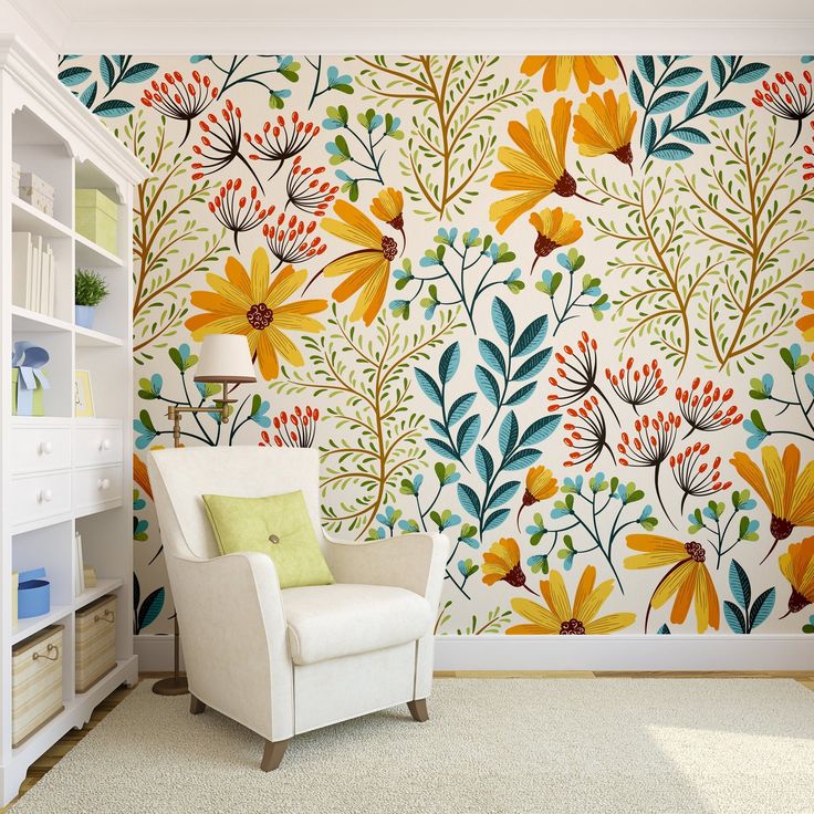 a white chair sitting in front of a wall with flowers painted on it's side