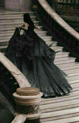 a woman in a long dress walking down some stairs