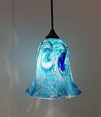 a blue glass light hanging from a ceiling