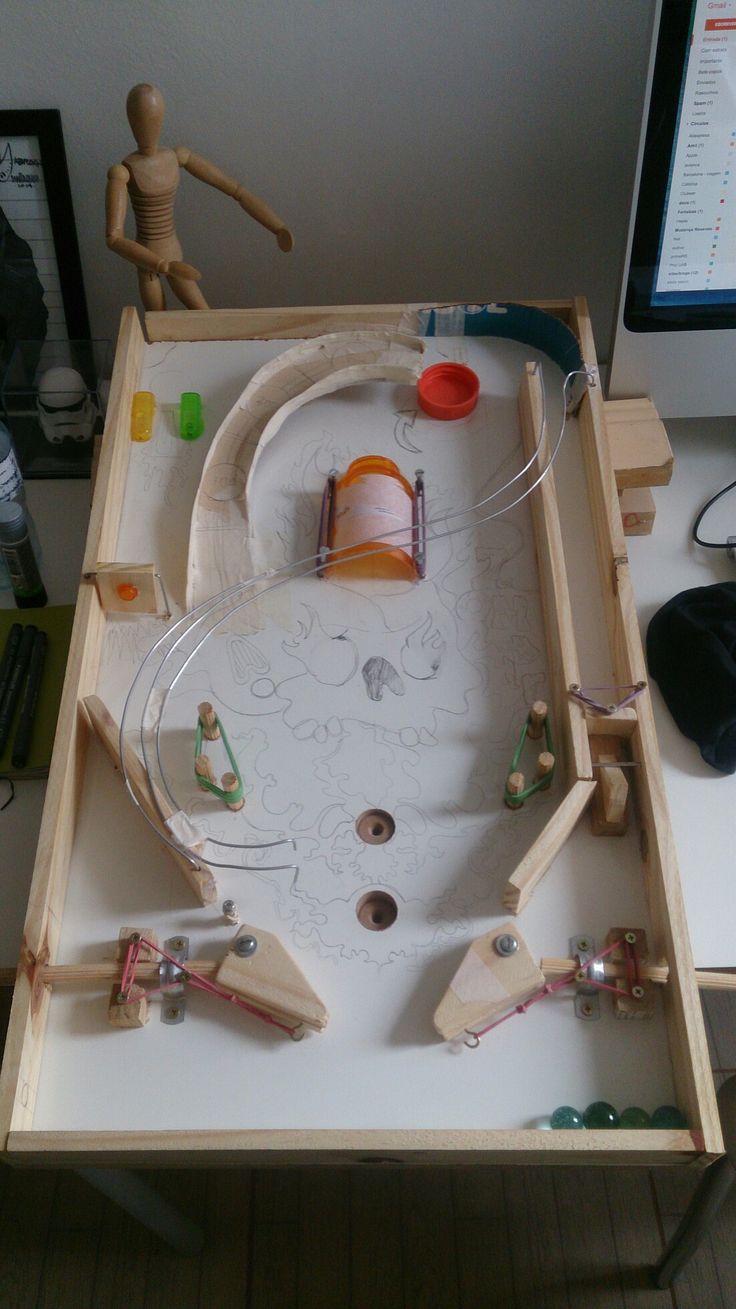 a wooden table topped with lots of toys and supplies on top of a white desk