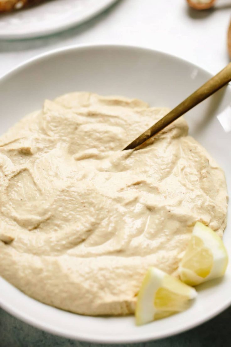 a white bowl filled with hummus sitting on top of a table