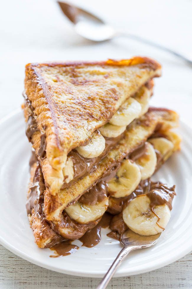 two slices of french toast with chocolate and bananas on them, one is cut in half