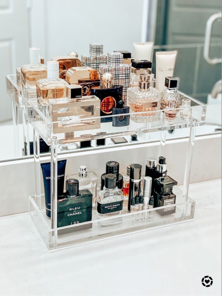 a clear shelf filled with lots of different types of perfumes on top of a counter