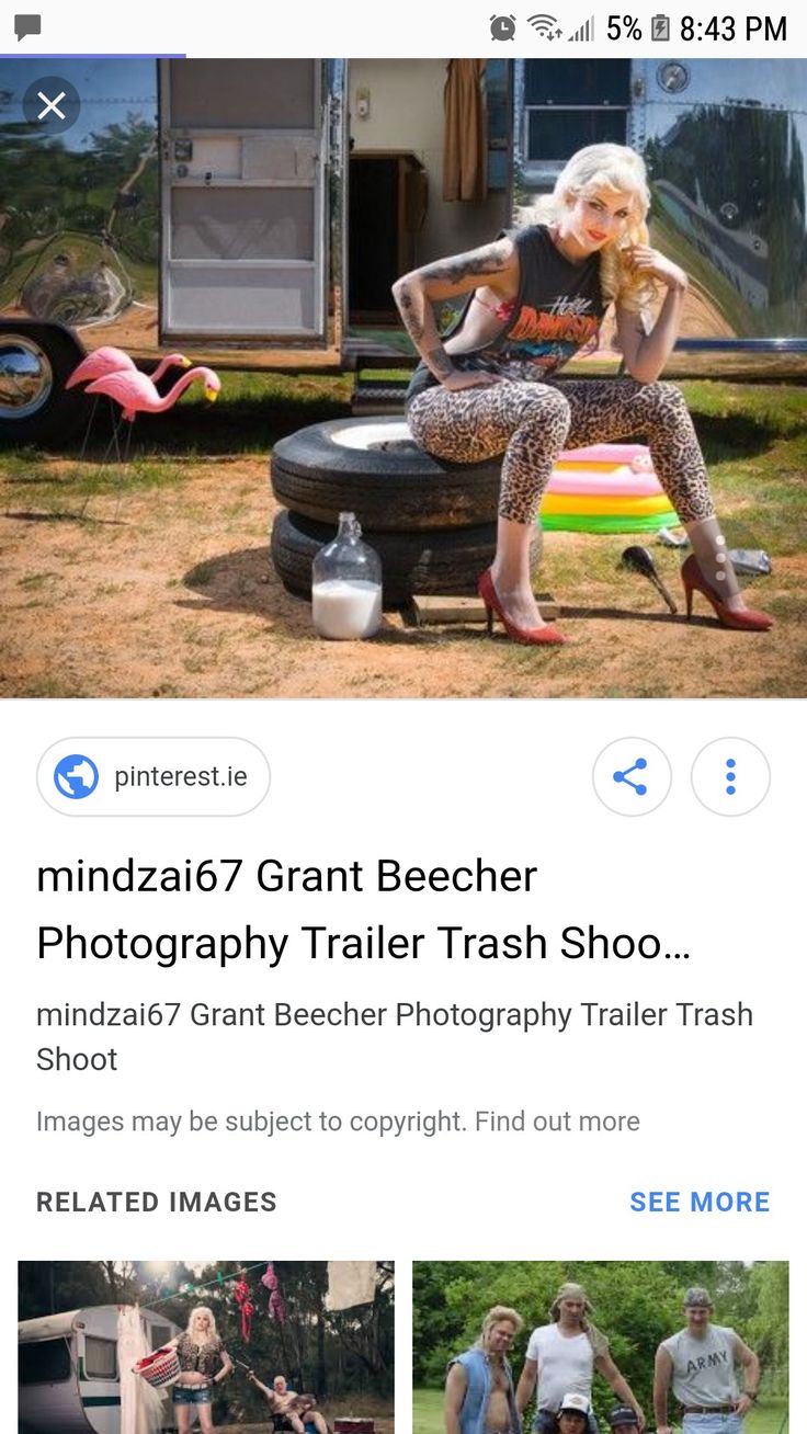 a woman sitting on top of a chair in front of a trailer and another person standing next to her