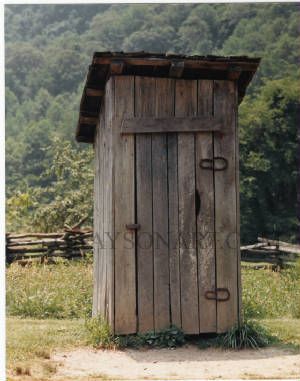 an outhouse in the middle of a field