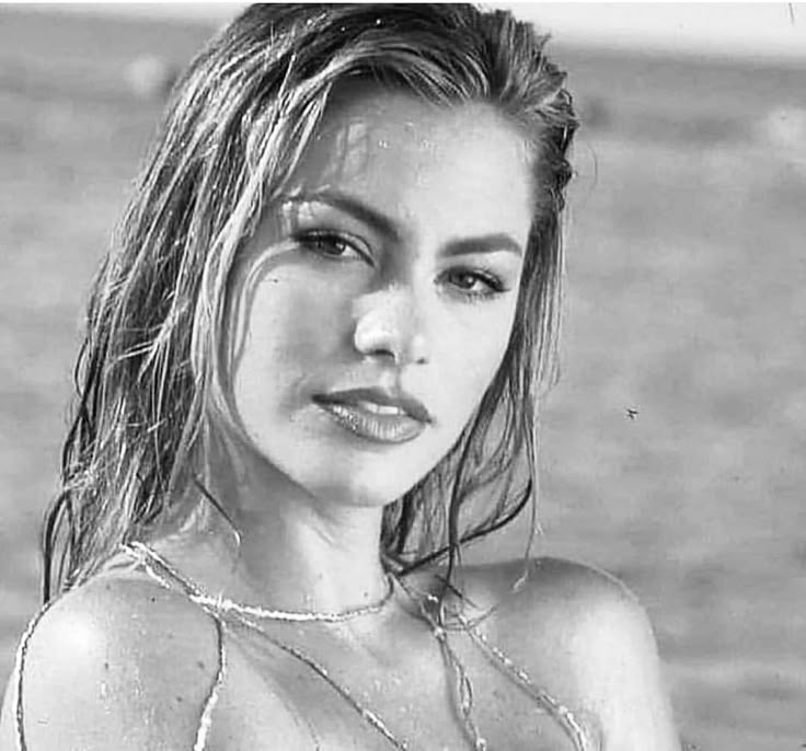 black and white photograph of a young woman in the water with her hair blowing back