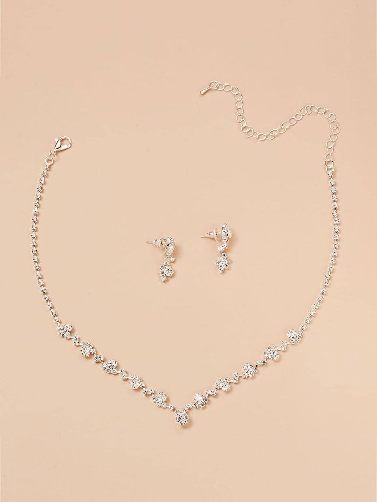 a necklace and earring set on a pink background