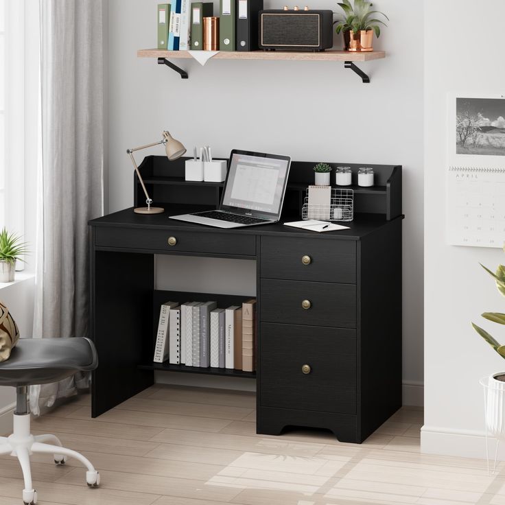 a desk with a laptop on top of it next to a chair and bookshelf