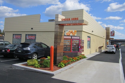 an outside view of a restaurant with cars parked in the parking lot