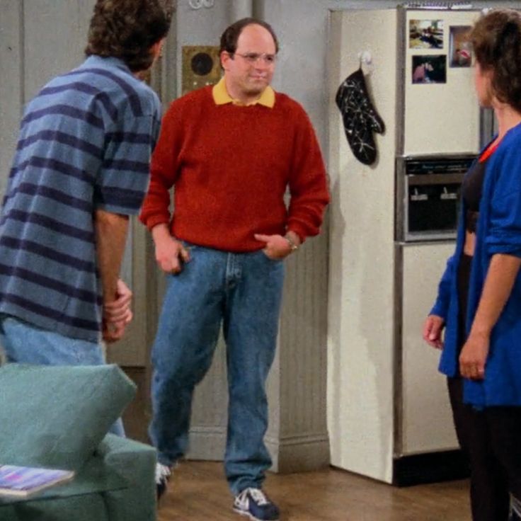 three people standing in a kitchen talking to each other