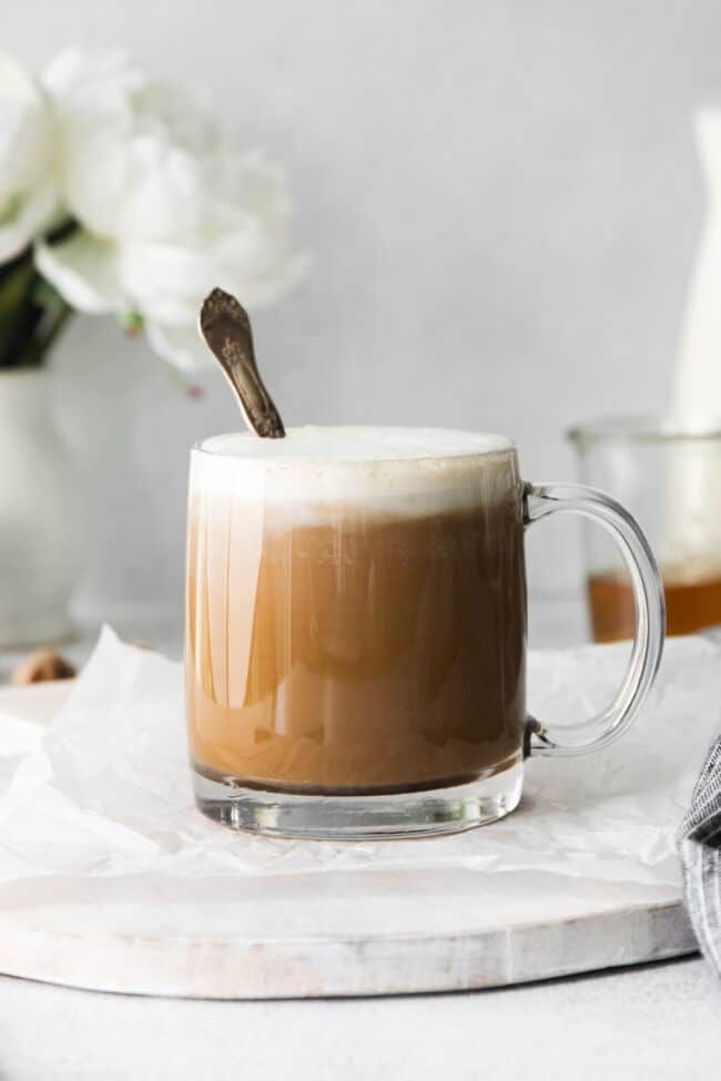 a person pours coffee into a glass mug