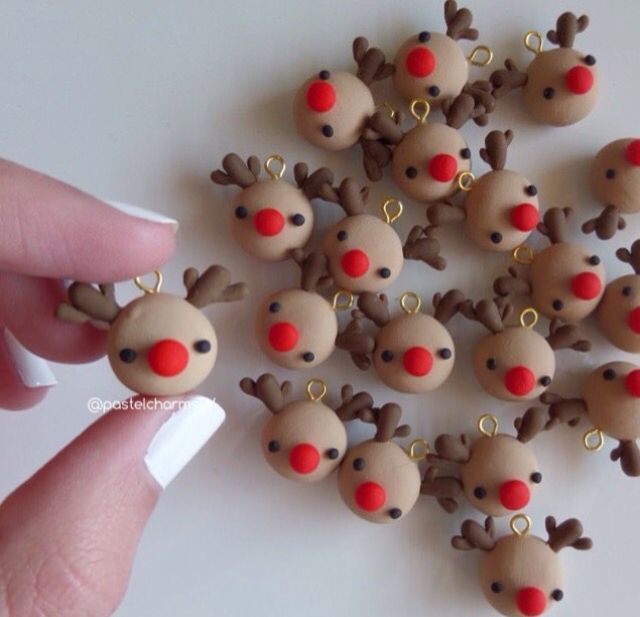 a hand is holding a bunch of tiny christmas reindeers with red noses and nose rings