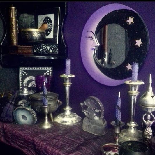 a table topped with lots of different types of candles next to a mirror and other items