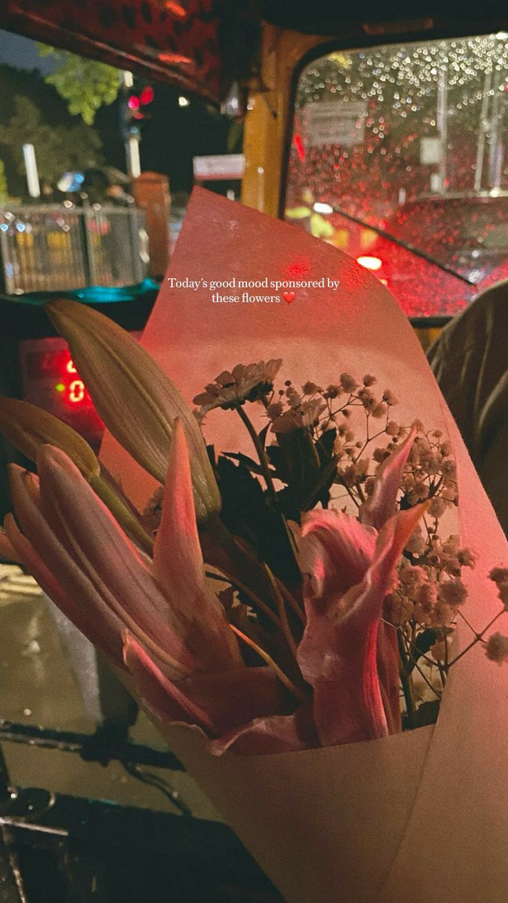 a bouquet of flowers sitting on top of a piece of paper in the back of a truck