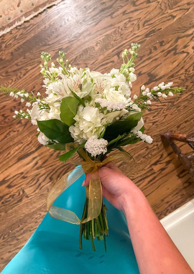 a person holding a bouquet of white flowers