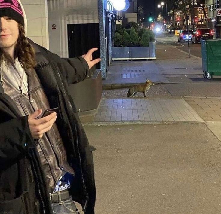 a woman standing on the sidewalk with her hand out