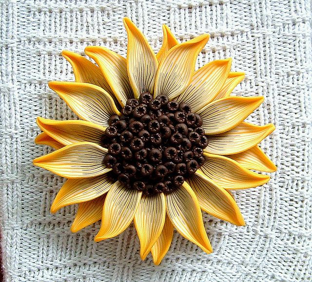 a yellow and brown sunflower sitting on top of a white cloth