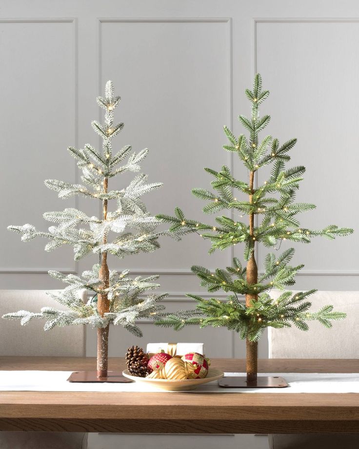 two small trees sitting on top of a wooden table