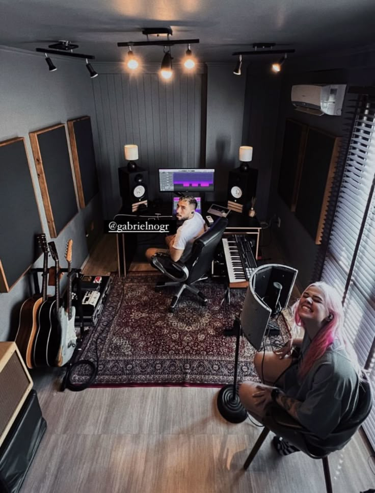 a man sitting in a recording studio with his guitar