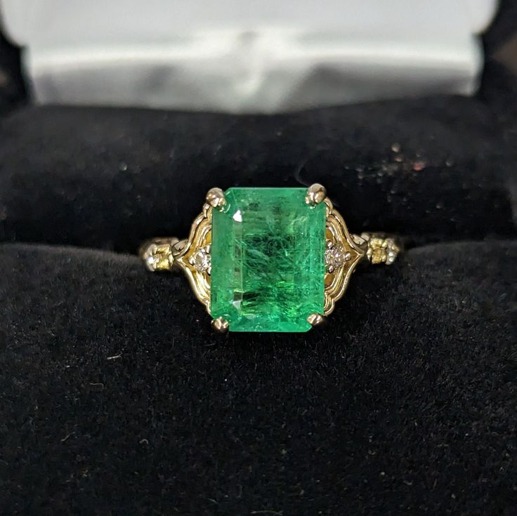 Fantastic Genuine 3.5 carat Zambian Emerald in a beautiful 14 karat yellow gold ring (size 7) with 4 white 1.7mm accent diamonds. The Emerald size is 10.01mm x 7.83mm x 5.26mm and is has minor oil applied (oiling is typical for emeralds). The GFCO Gem Lab testing document to confirm authenticity is included. Simply Stunning! Genuine Emerald Ring, Art Deco Emerald Engagement Ring, Formal 14k Gold Emerald Ring With Diamond Accents, Emerald Cut Yellow Gold Diamond Ring, Formal Yellow Gold Emerald Ring With Center Stone, Yellow Gold Emerald Diamond Ring With Vvs Clarity, Heirloom Emerald Ring In Yellow Gold With Diamond Cut, Classic Emerald Ring With Diamond Stamped 14k, Classic Emerald Ring With Diamond And 14k Stamp